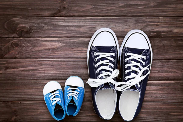 Babalar Günü konsepti. Kahverengi ahşap masada babanın ve oğlunun ayakkabıları.