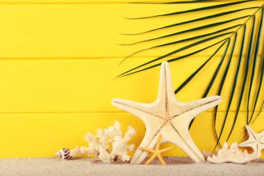 Sarı zemin üzerinde mercan ve palmiye yaprağı olan yıldız balıkları