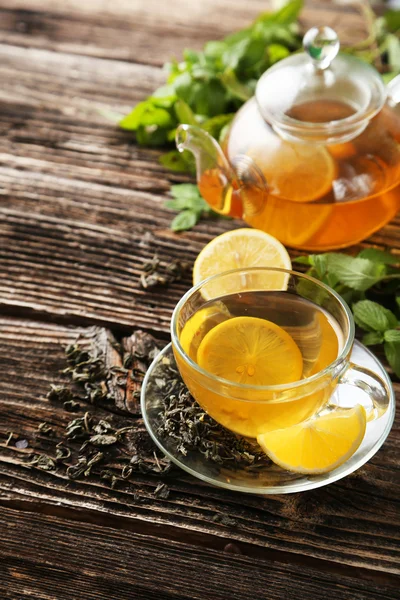 Pohár s zelený čaj a konvici na hnědé dřevěné pozadí — Stock fotografie