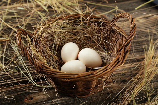 Яйца на сене в корзине — стоковое фото