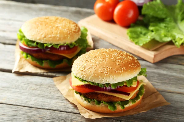 Fresh burgers on cutting board — Stock Photo, Image