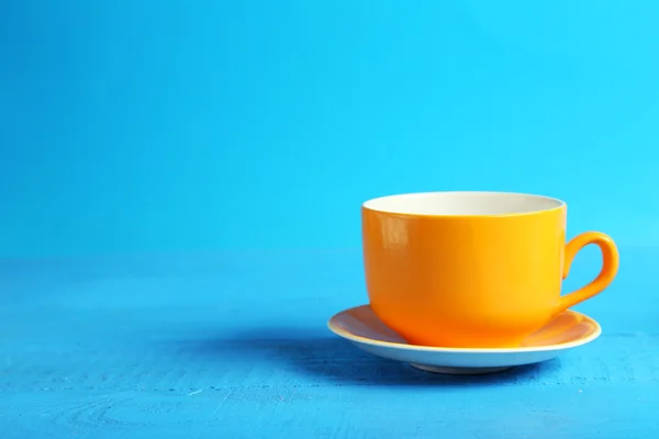 Taza naranja aislada en azul — Foto de Stock