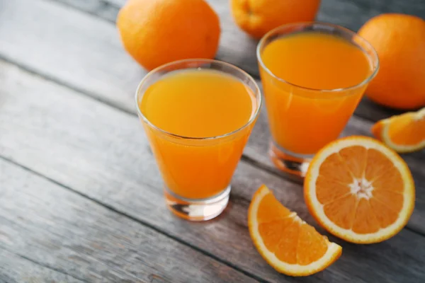 Glasses of orange juice with fruits — Stock Photo, Image