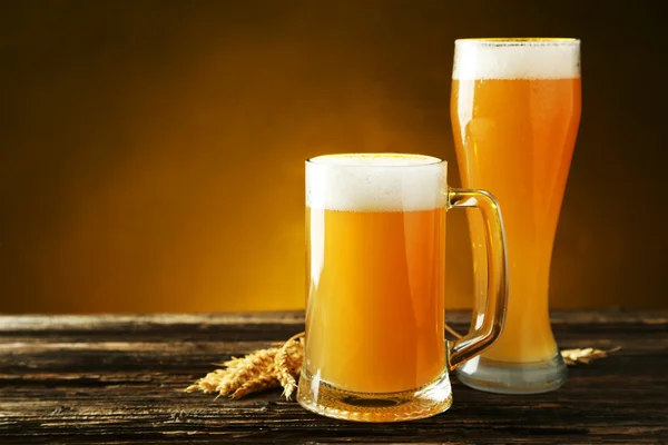 Glass and mug of beerwith ears of wheat — Stock Photo, Image