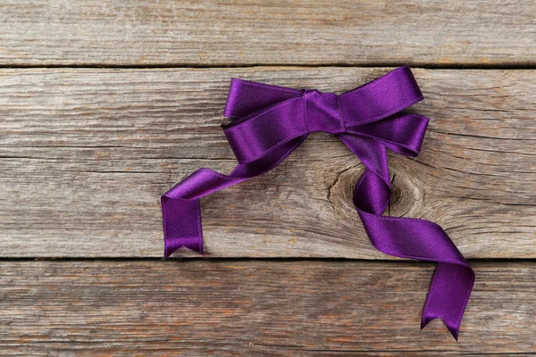 Purple bow wooden background — Stock Photo, Image