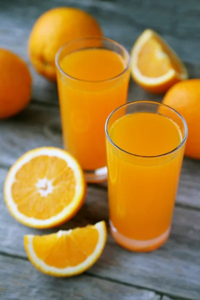 Glasses of orange juice with fruits — Stock Photo, Image