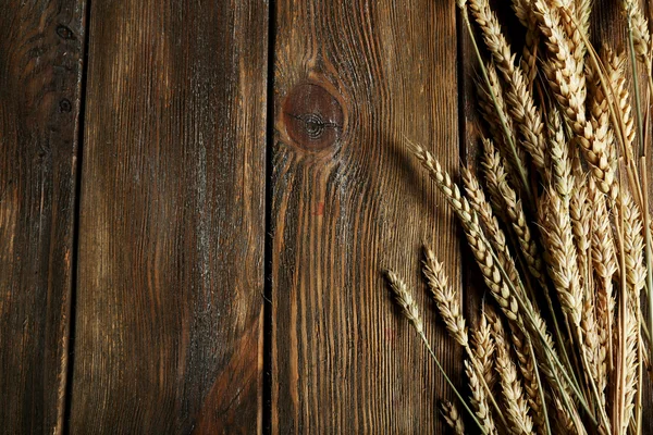 Orecchie di grano su sfondo di legno — Foto Stock