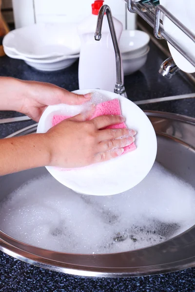 Vrouwelijke hand wassen schotel — Stockfoto