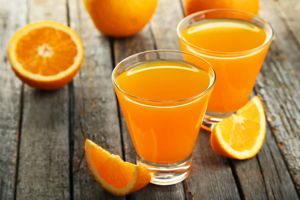 Glasses of orange juice with fruits — Stock Photo, Image