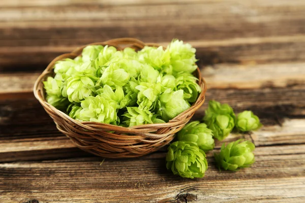 Hops in basket on wooden background — Stock Photo, Image