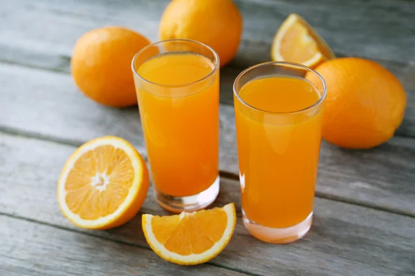 Glasses of orange juice with fruits — Stock Photo, Image