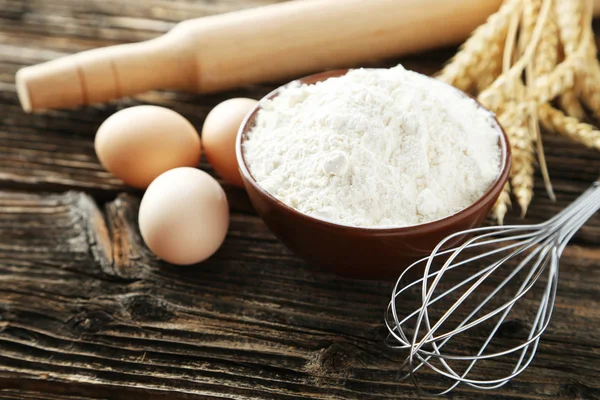 Tigela de farinha de trigo com ovos — Fotografia de Stock