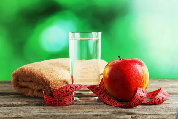 Apple with measuring tape and glass of water — Stock Photo, Image