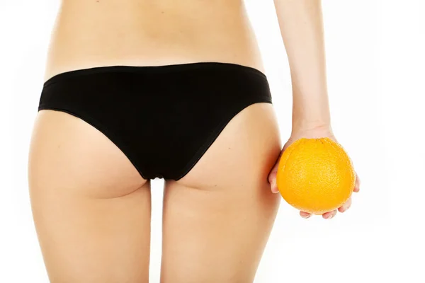Mujer joven sosteniendo naranja — Foto de Stock