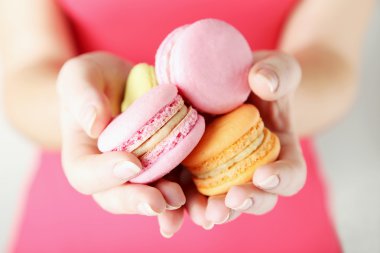 Renkli macarons holding eller