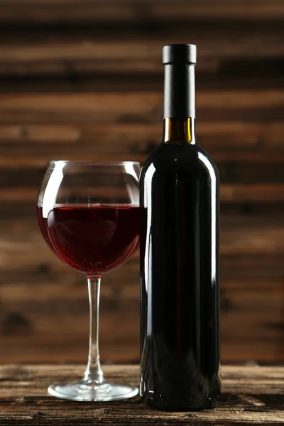 Бокал красного вина с бутылкой — стоковое фото