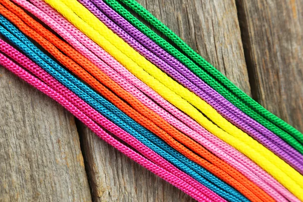 Cordas coloridas em fundo de madeira — Fotografia de Stock