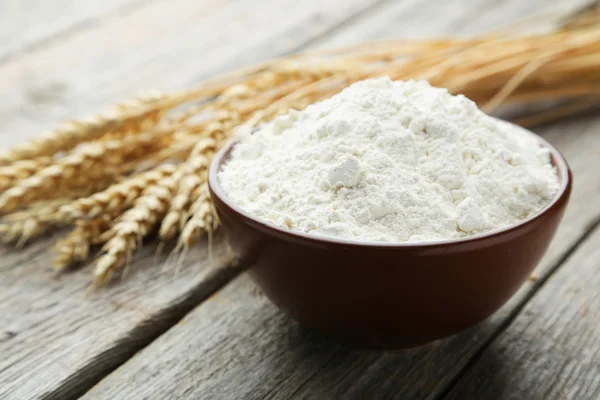 Bowl of wheat flour with spikelets — Stock Photo, Image