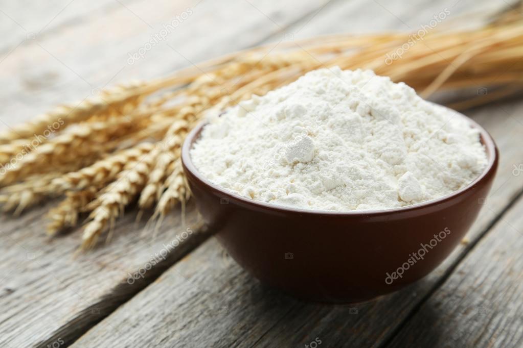 Bowl of wheat flour with spikelets