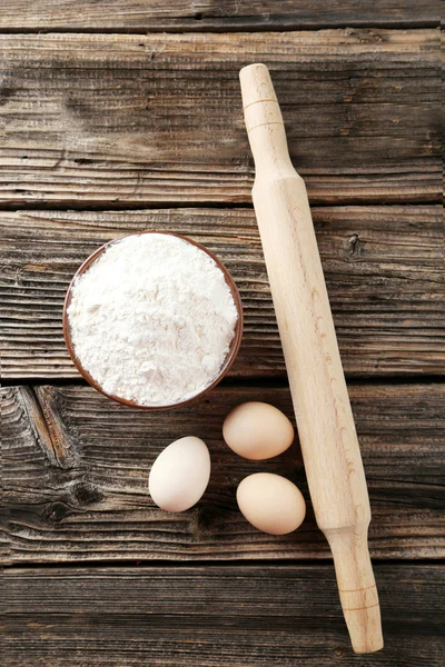 Mattarello con uova e ciotola di farina di frumento — Foto Stock