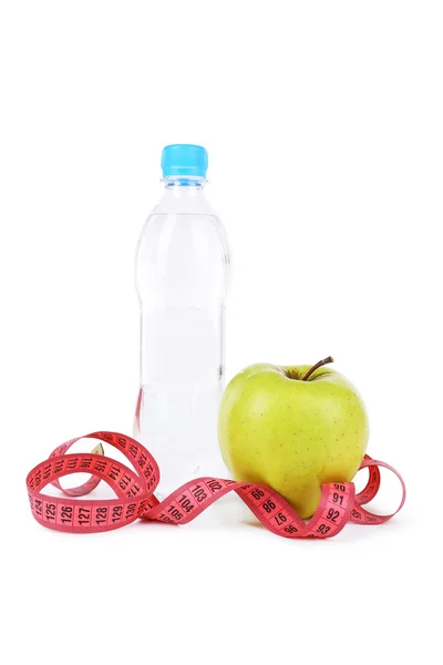 Яблоко с измерительной лентой и бутылкой — стоковое фото
