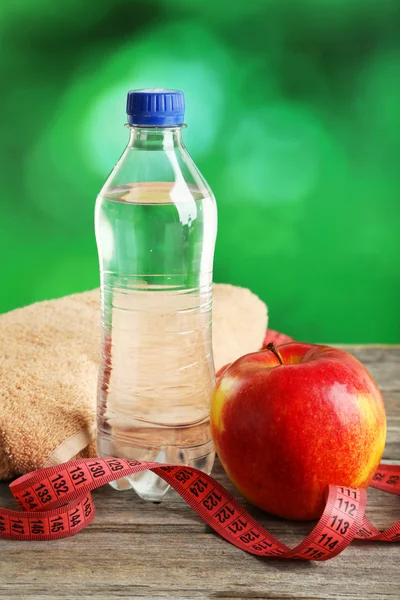 Apple with measuring tape and bottle of water — Stock Photo, Image