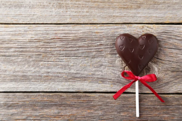 Coração de chocolate no fundo de madeira — Fotografia de Stock