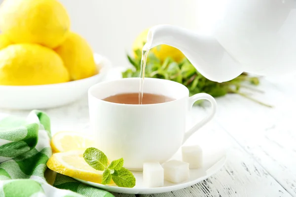 Despejando chá em xícara de chá — Fotografia de Stock