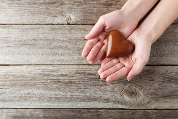 Woman's hands with chocolate heart — Stock Photo, Image