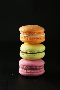 Siyah arka plan üzerinde renkli macarons Fransız