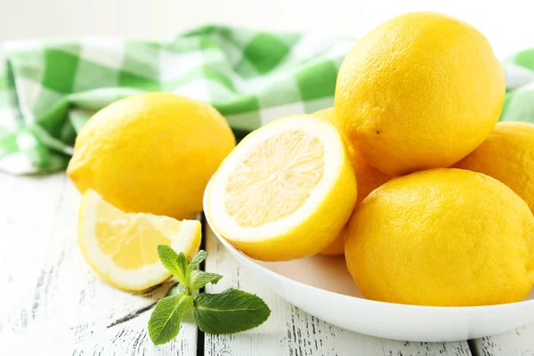 Lemons in bowl on white wooden background — Stock Photo, Image