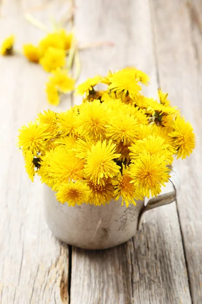 Yellow dandelions in cup — Stock Photo, Image