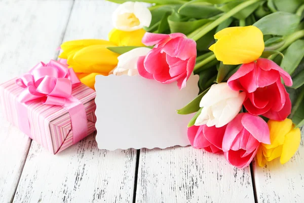 Hermosos tulipanes con tarjeta y regalo —  Fotos de Stock