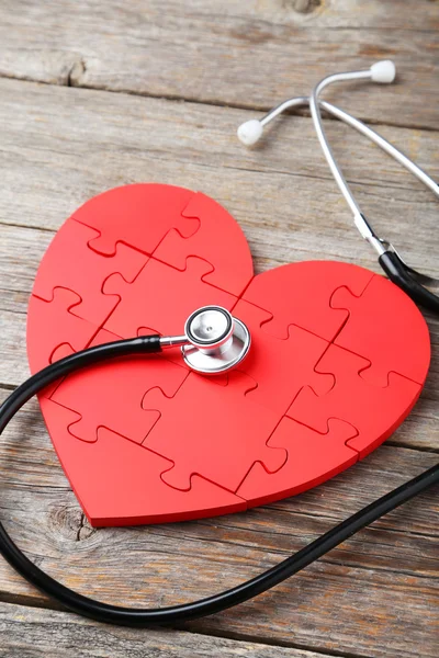 Corazón rompecabezas rojo con estetoscopio —  Fotos de Stock