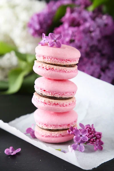 Pink macaroons with lilac flowers — Stock Photo, Image