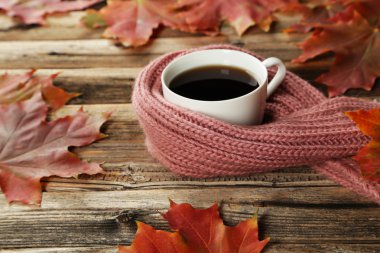 Sonbahar yaprakları ve sıcak bir eşarp ile kahve