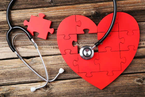 Rød puslespil hjerte med stetoskop - Stock-foto