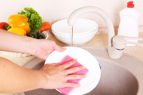 Руки з губкою миття посуду — стокове фото