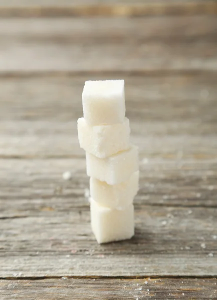 Sugar cube on grey wooden background — Stock Photo, Image