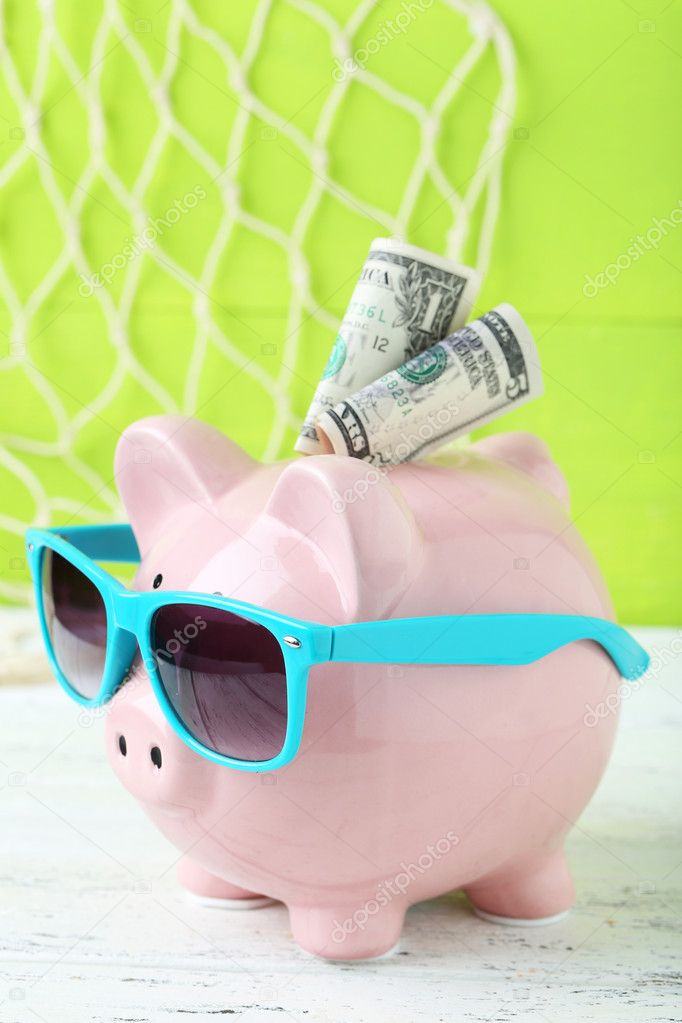 Pink piggy bank with dollars