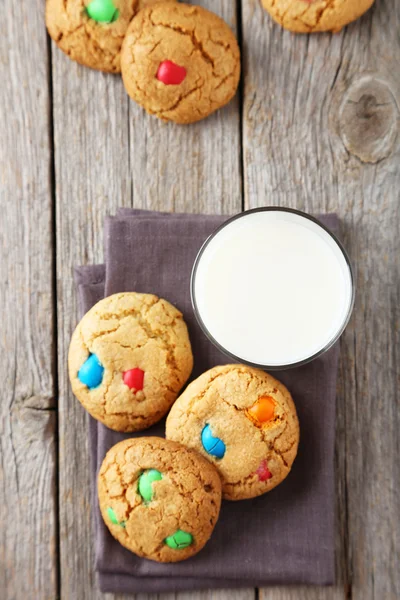 Kekse mit bunten Bonbons auf grauem Holzhintergrund — Stockfoto