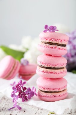 Fransızca macarons Beyaz ahşap backgrou üzerinde Eflatun çiçekli pembe