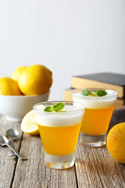 Tasty lemon jelly in glass on grey wooden background — Stock Photo, Image