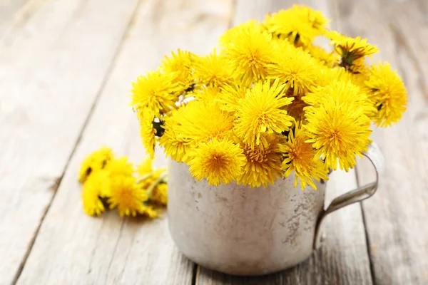 Yellow dandelions in cup — Stock Photo, Image