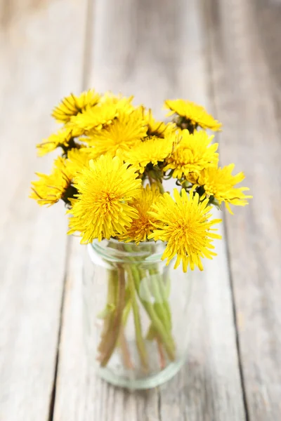 Yellow dandelions in bottle — Stock Photo, Image