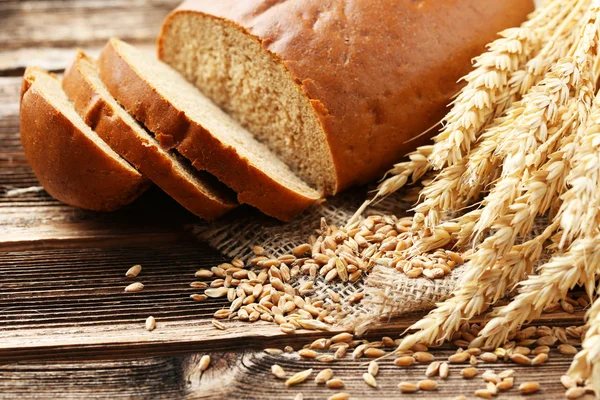 Уши пшеницы с зерном и хлебом — стоковое фото