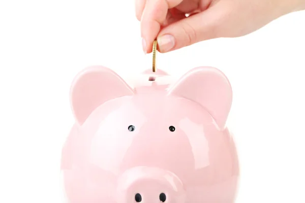 Hand putting coin into pink piggy bank — Stock Photo, Image