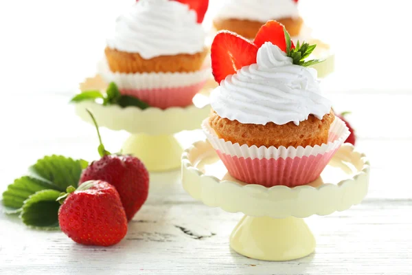 Välsmakande cupcake med jordgubbar på tårta — Stockfoto