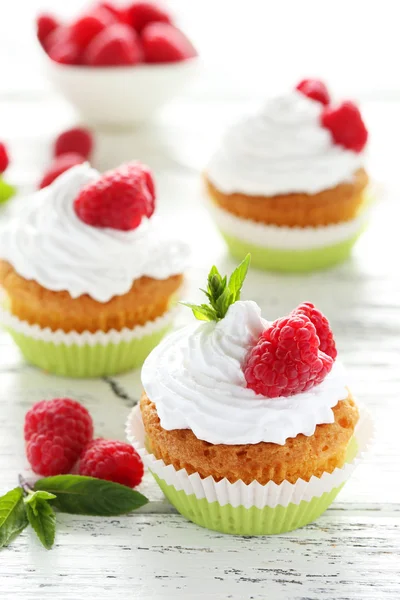 Cupcakes de frambuesa sobre fondo de madera blanca — Foto de Stock