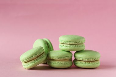 Pembe kağıt arka plan üzerinde yeşil macarons